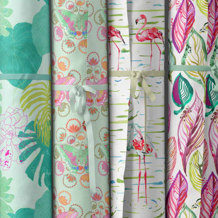 sandra banava selection of new fabric rolls showing tropical leaves flamingos pink and green leaves and butterflies in a painterly modern watercolor style